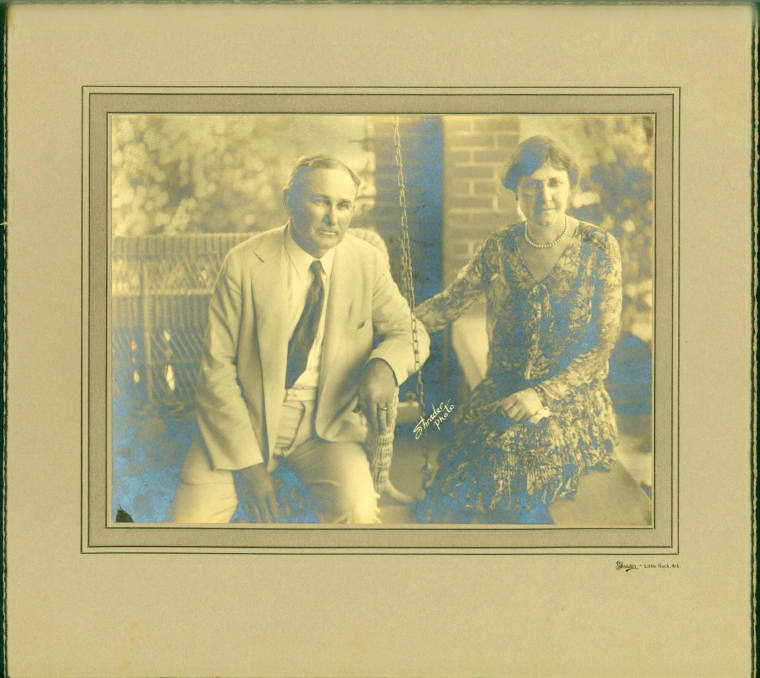 Photo of Joe Robinson and his wife seated on porch of a house