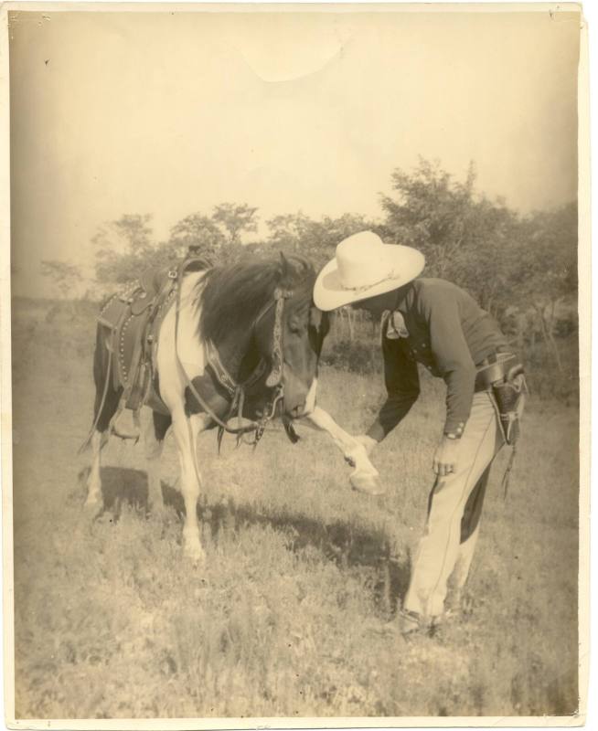 photo - cowboy shaking horse hoof