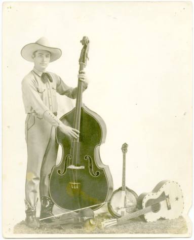 Photo of a cowboy and four stringed instruments.