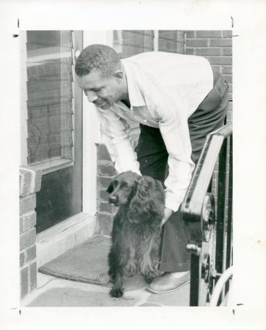 Al Hibbler photo with him petting a black dog.