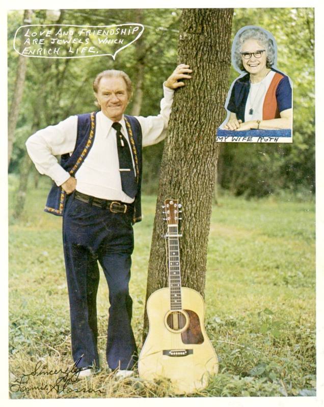 Color 8x10 of Lonnie Glosson. Glosson is posed leaning up against a tree wearing a navy pants,  ...