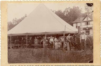 photo of people around a carousel under a tent