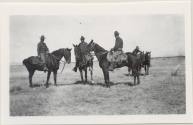 Photo of 4 men mounted on horses.