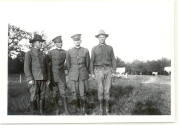 Photo of 4 men in a field.