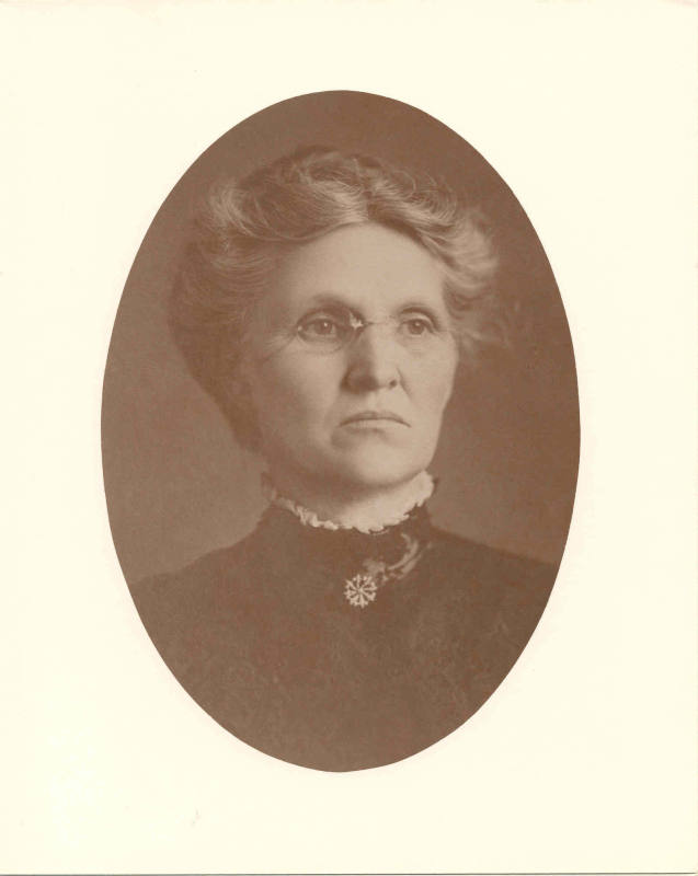 Photo of Mrs. Little wearing a high-necked black lace dress.