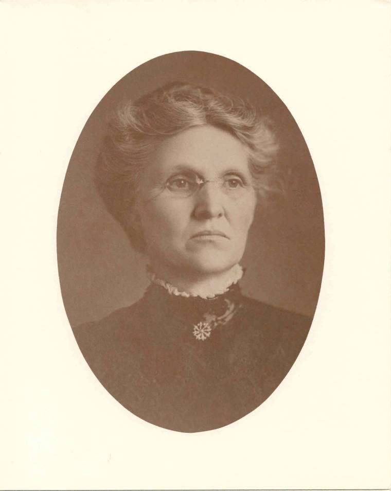 Photo of Mrs. Little wearing a high-necked black lace dress.