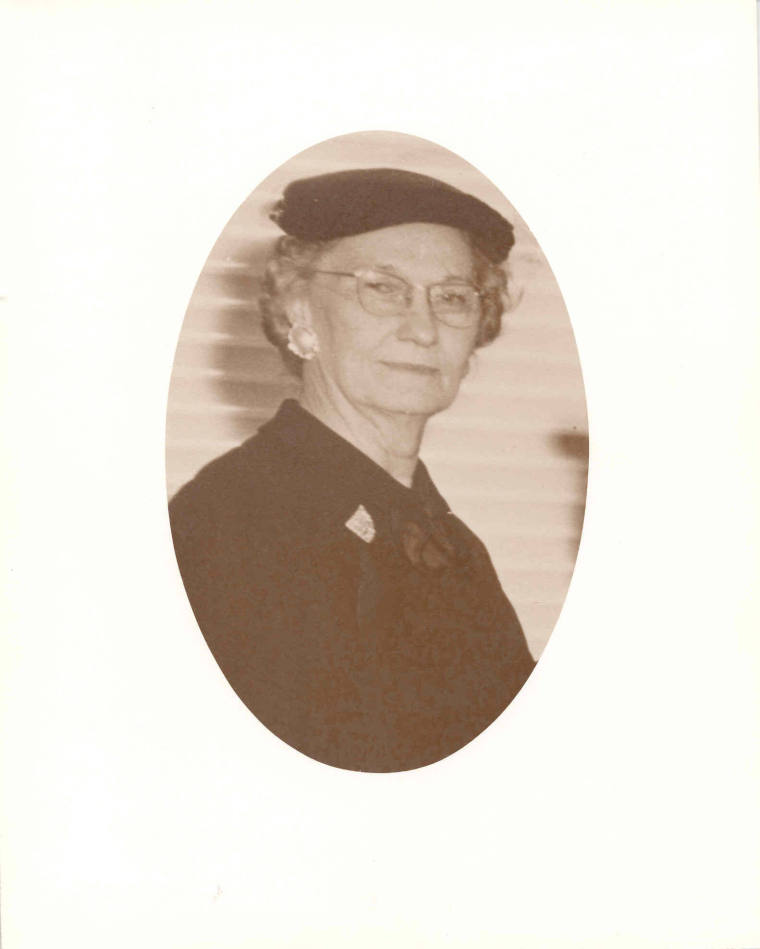 Photo of Mrs. H. Adkins wearing a black suit, hat, and a broche.