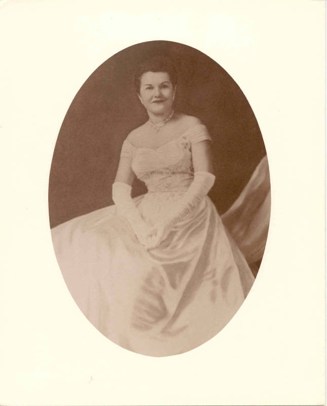 Photo of Mrs. Faubus in a white gown with a necklace & earrings. 