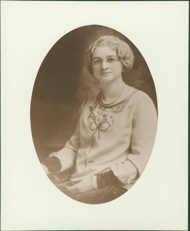 Photo of Mrs H Parnell in a dress & pearls looking at the camera.