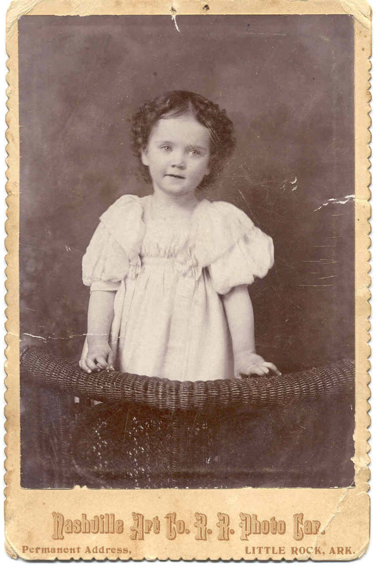 Janie Davis as a young girl with curled hair wearing white dress