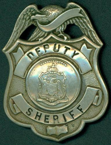 Silver colored badge with "Deputy Sheriff" across the shield.