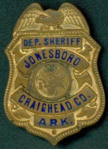 Small gold badge worn by a Deputy Sheriff in Jonesboro.