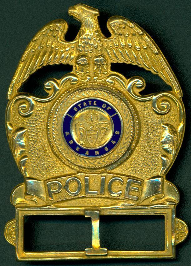 Gold hat badge for an Arkansas State Trooper